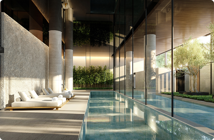 Zona wellness de lujo con piscina interior climatizada, tumbonas de diseño y entorno natural, parte de una Branded Residence de alta gama.