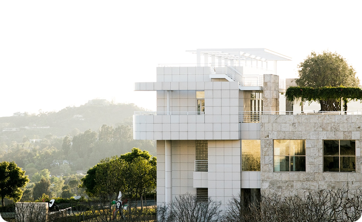 Edificio residencial de lujo con diseño geométrico moderno, fachada blanca modular y vegetación integrada, ejemplo de Branded Residence en entorno natural elevado.